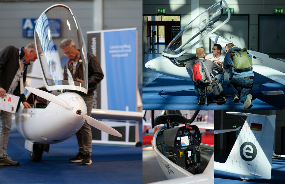 SZD-55-1 Nexus mit geöffnetem Cockpit am Messestand, Elektromotor sichtbar.
